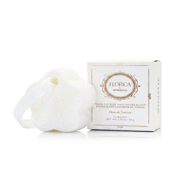 Spongellé Fleur de Narcisse Spongette body wash infused buffer resting on a textured travertine surface.