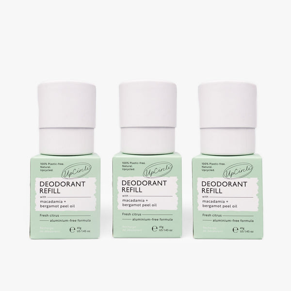 UpCircle Macadamia and Bergamot deodorant refills presented in sustainable cardboard packaging on a travertine plinth.