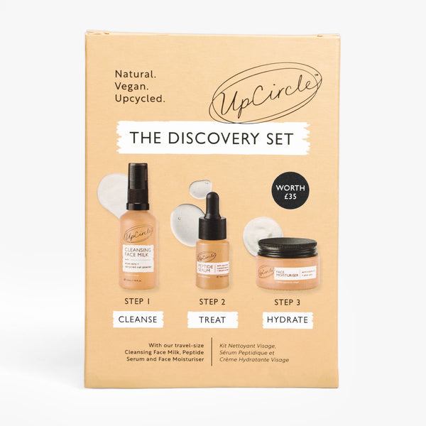 UpCircle The Discovery Set featuring a curated selection of sustainable skincare bottles arranged on a travertine plinth.