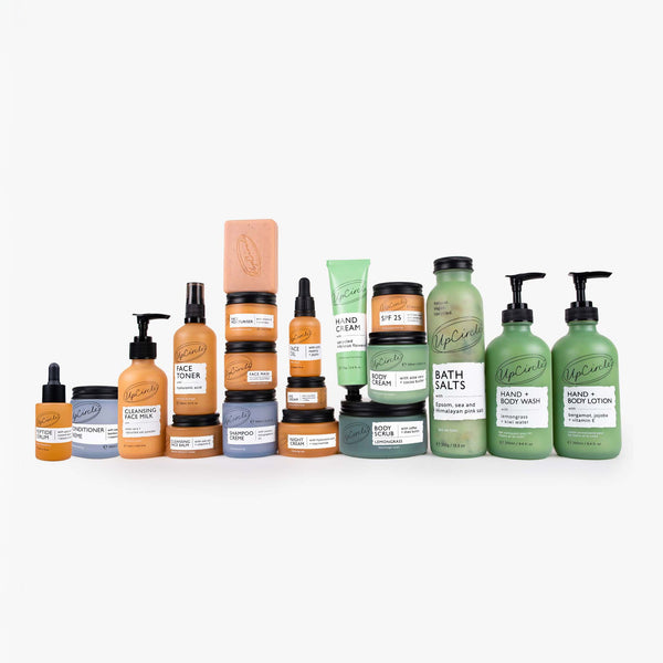 UpCircle The Full House Bundle featuring skincare products in sustainable glass and aluminum containers on a stone plinth.