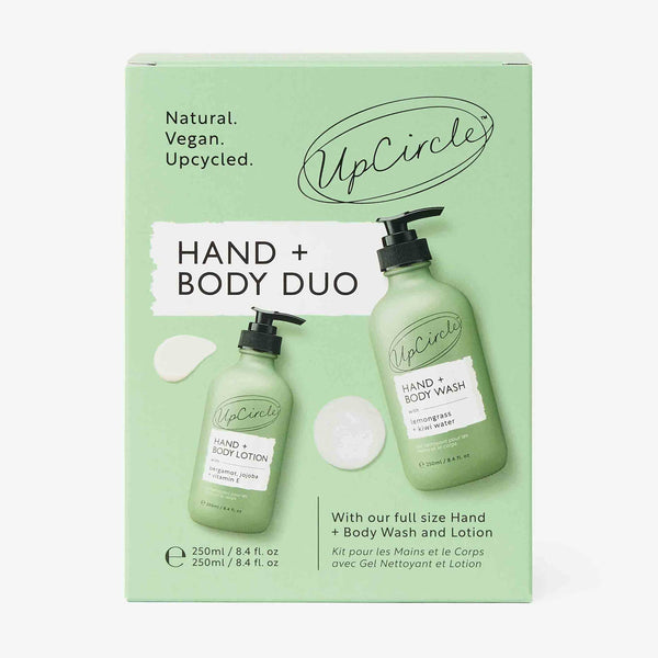 UpCircle Hand + Bodycare Duo in sleek, sustainable amber glass bottles set against a minimalist travertine surface.