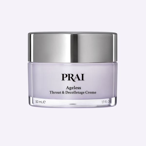PRAI Beauty Ageless Throat & Decolletage Creme in a sleek gold and cream jar, displayed on a textured stone plinth.
