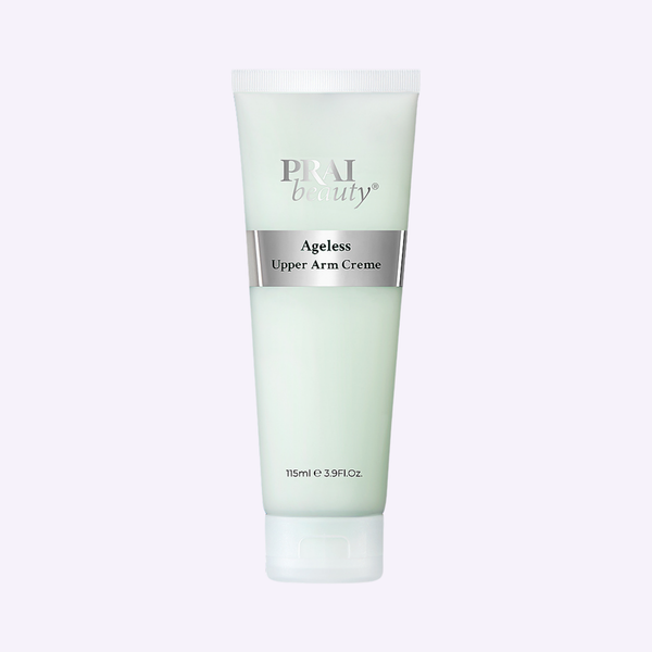 PRAI Beauty Ageless Upper Arm Creme in a sleek white jar, elegantly placed on a textured travertine plinth.