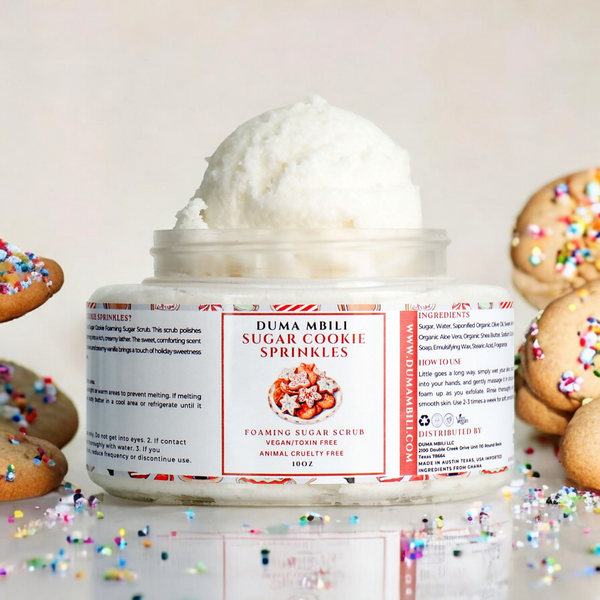 Adorn Collective Sugar Cookie Sprinkles Foaming Sugar Scrub in a clear glass jar on a travertine surface.