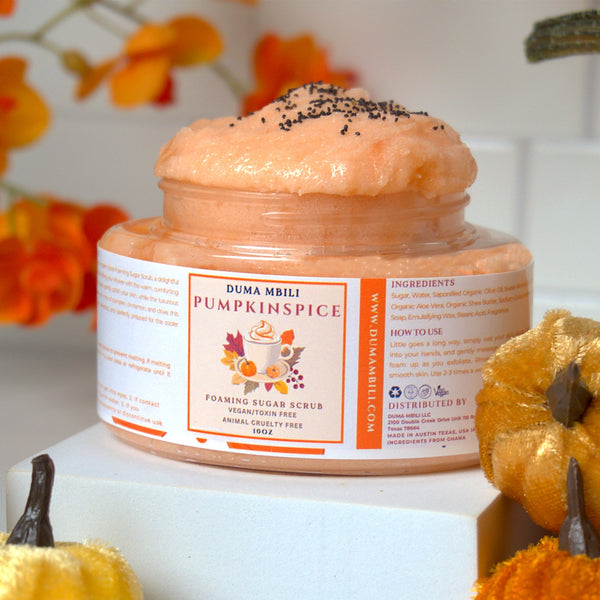Adorn Collective Pumpkin Spice Foaming Body Scrub by Duma Mbili LLC in a minimalist jar on a textured travertine plinth.