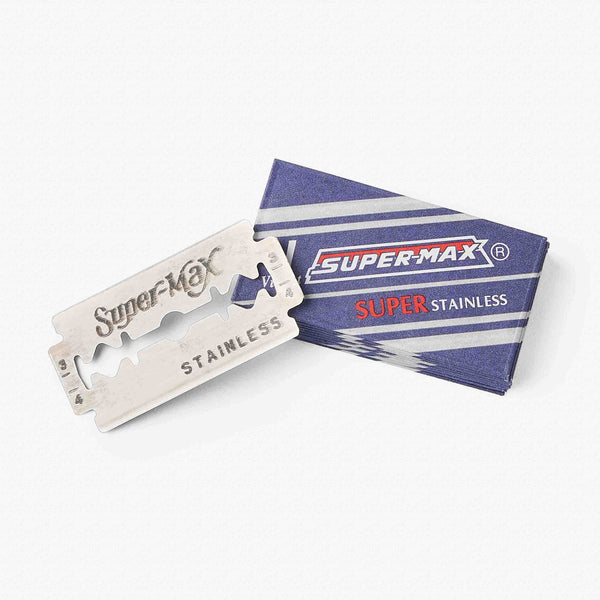UpCircle refill safety razor blades pack of 10 resting on a beige travertine plinth with raw silk linen texture.