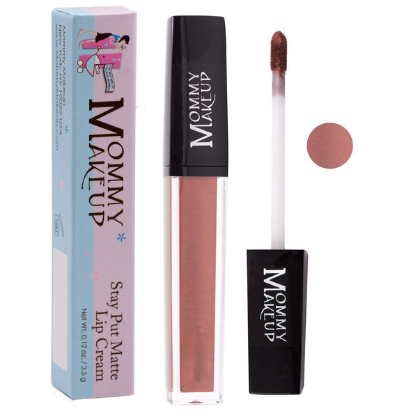 Mommy Makeup Pennie Stay Put Matte Lip Cream in a sleek, minimalist bullet container resting on a beige travertine plinth.