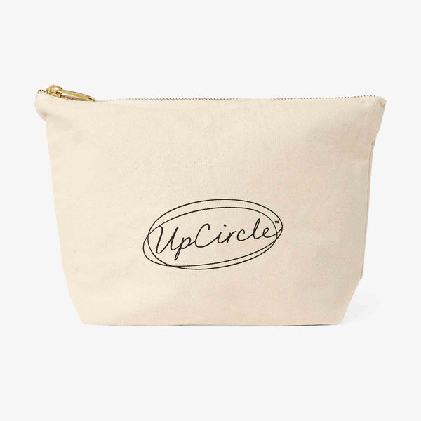 UpCircle Cotton Wash Bag displayed on a textured travertine plinth, featuring a minimalist aesthetic with raw fabric.