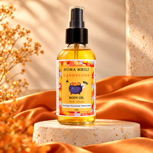 Adorn Collective Candy Corn Body Oil by Duma Mbili LLC in a minimalist glass bottle resting on a textured travertine base.