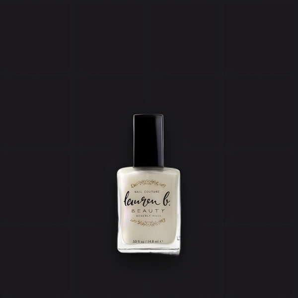 Lauren B. Beauty Glazed and Confused nail polish bottle resting on a travertine surface with elegant, clean branding.