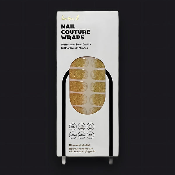 Lauren B. Beauty Gold Dusted Gel Nail Wrap strip on a warm travertine surface with soft natural lighting.