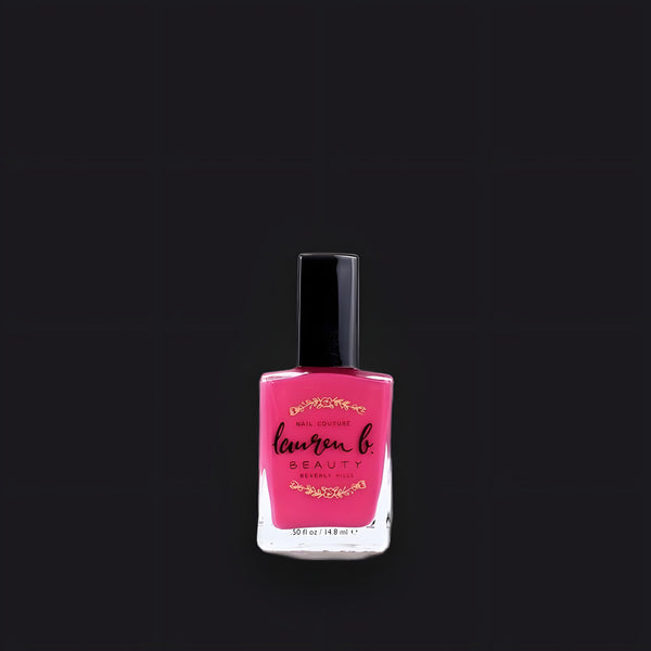 Lauren B. Beauty #ImSoLA nail polish bottle displayed on a textured travertine plinth against raw champagne silk.