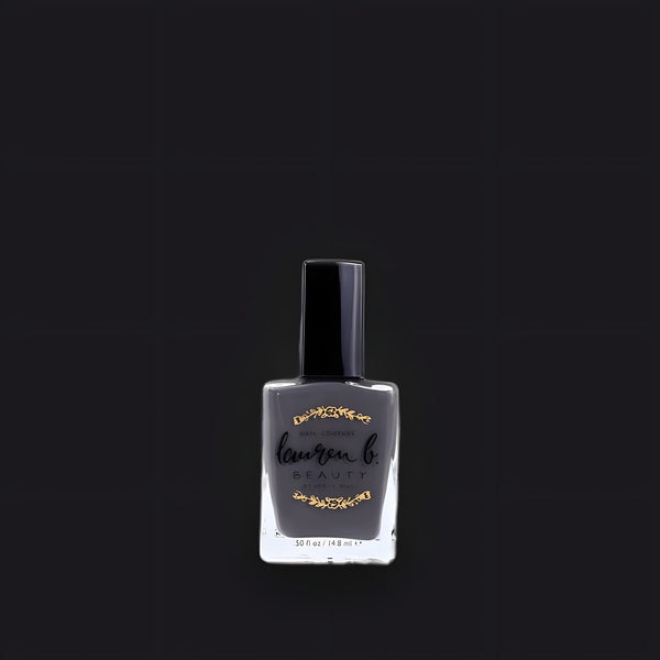 Lauren B. Beauty L.A. Smog nail polish in a signature luxury glass bottle atop a textured travertine surface.