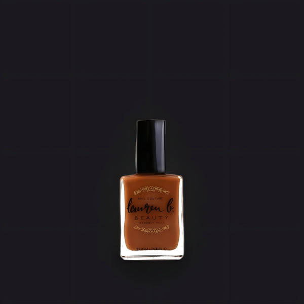 Lauren B. Beauty Runyon Canyon 7-free vegan nail polish bottle sitting on a textured travertine surface.