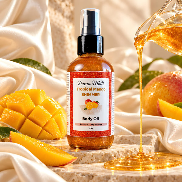 Adorn Collective Tropical Mango Shimmer Body Oil in a sleek glass bottle resting on a textured travertine plinth.